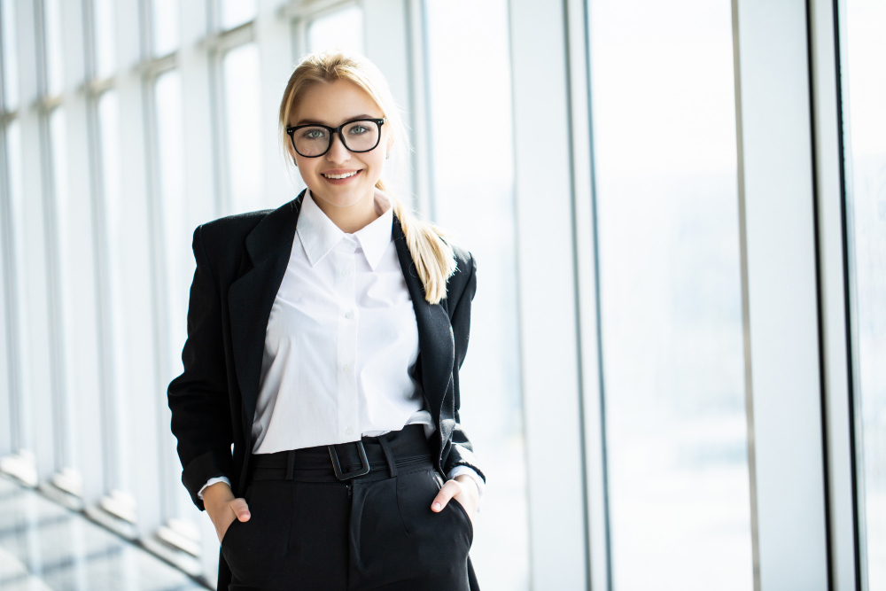 young blonde woman with crossed hands is standing corner panoramic office